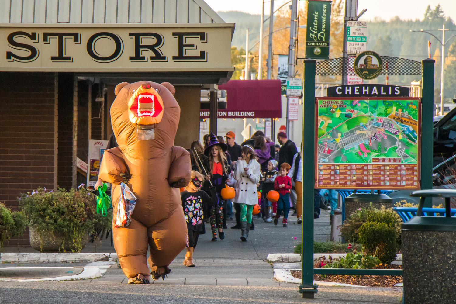 FILE PHOTO — Isaiah Grady sports a blowup bear costume as he runs down the sidewalk during Halloween festivities in Chehalis in 2019.